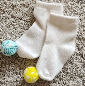 LOVEVERY Play Socks - White Baby Socks with Yellow and Blue Rattles